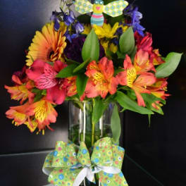 Colorful bouquet in a glass vase with a decorative butterfly topper