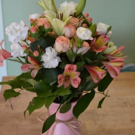 Pink and white mixed bouquet in a pink vase with ribbon