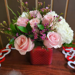 Pink roses and white hydrangea in a red square vase