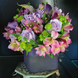 Purple and pink mixed bouquet in a lavender vase