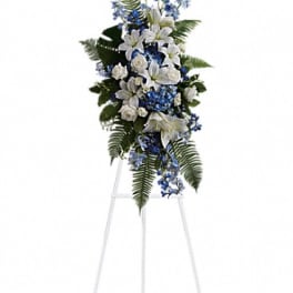 Tall white and blue floral standing spray on an easel
