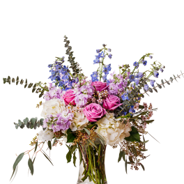 Pink roses and lavender flowers in a clear glass vase