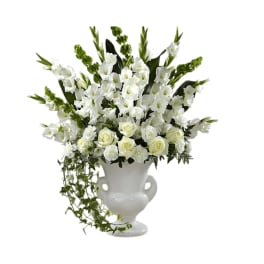 White floral arrangement in a white urn vase