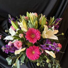 Bouquet of pink gerbera daisies, white lilies, and purple flowers