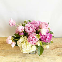 Pink peonies and hydrangea in a clear glass vase