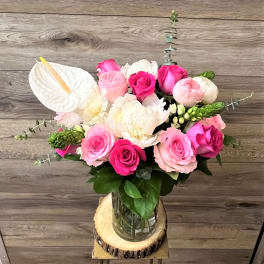 Pink and white roses with anthurium in a glass vase