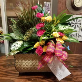 Mixed floral arrangement in a textured rectangular container with a plaid ribbon