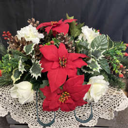 Holiday floral arrangement with red and white poinsettias and pinecones