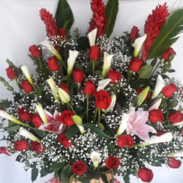 Tall basket arrangement of red roses, white calla lilies, and pink lilies with baby’s breath