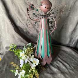 Metal angel figurine with white flowers and greenery at the base