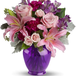 Pink and purple flower arrangement in a purple vase