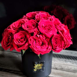 Bouquet of bright pink roses in a black hatbox