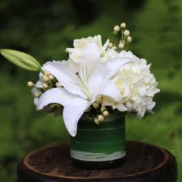 White lily and hydrangea arrangement in a green container