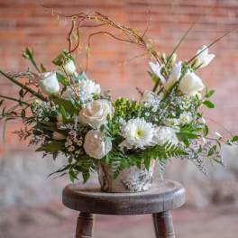 White floral arrangement in a rustic metal container