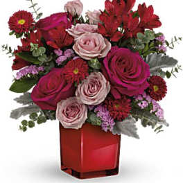 Pink and red rose bouquet in a red square vase