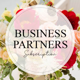 Floral arrangement with roses and other blooms behind a business partners subscription graphic