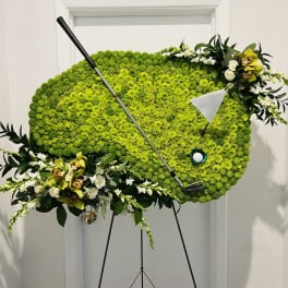 Golf-themed floral display with a golf club and ball on an easel