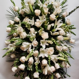 Large white floral standing spray with roses and lilies