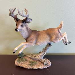 Decorative deer figurine leaping on a faux wood base