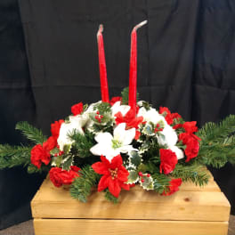 Red and white floral centerpiece with two tall red candles