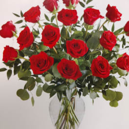 Red roses arranged in a clear glass vase