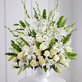 White floral arrangement in a white pedestal vase