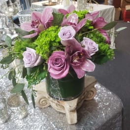 Lavender roses and pink orchids in a dark vase