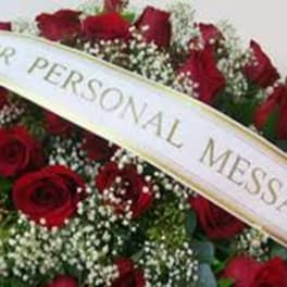 Red roses with baby's breath and a personal message ribbon