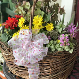 Basket of yellow and red flowers with a polka-dot ribbon bow
