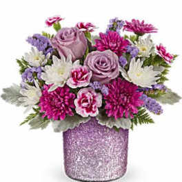 Pink and lavender flowers arranged in a glittery purple vase