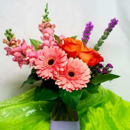 Pink gerbera daisies and orange roses in a vase
