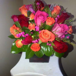 Bouquet of pink, red, and orange roses with greenery