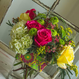 Bouquet of pink and yellow roses with pale hydrangea in a glass vase