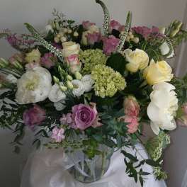 Large bouquet of pink, white, and yellow flowers in a glass vase
