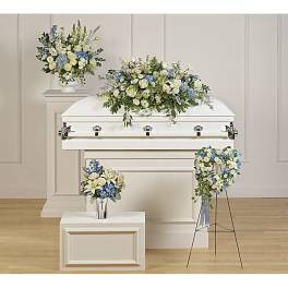 White casket with blue and white floral sprays