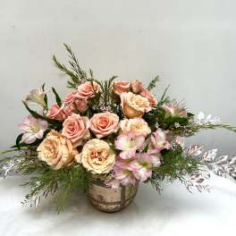 Peach roses and pink alstroemeria in a rustic vase