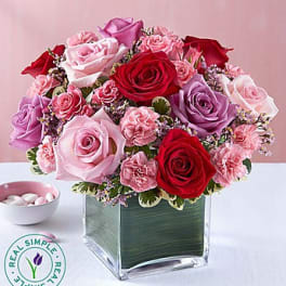 Pink and red rose bouquet in a square glass vase