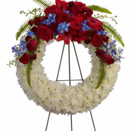 Red and white floral wreath on a black stand