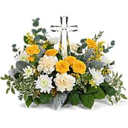 Low yellow and white flower arrangement with a clear crystal cross in the center.