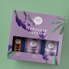 Lavender therapy gift set box with three lavender oil products on a green background