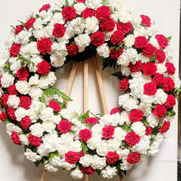 Large red and white carnation wreath on a wooden easel