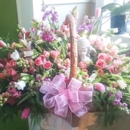 Basket of pink and white flowers with a pink bow
