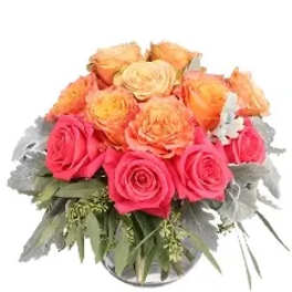 Pink and peach roses arranged in a glass vase