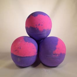 Three purple and pink bath bombs stacked in a pyramid