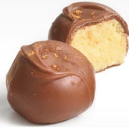 Two chocolate truffles, one cut open to show a creamy filling