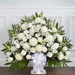 White floral arrangement with roses and daisies in a vase, tied with a white ribbon