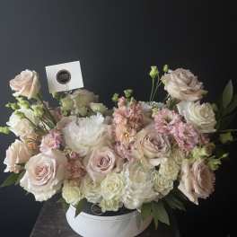 Blush and white roses with pink blooms in a white hat box