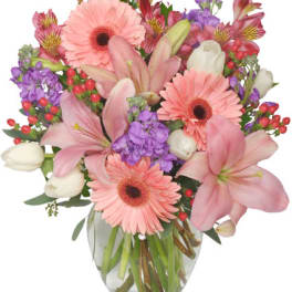 Pink lilies and gerbera daisies in a clear glass vase