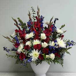 Red and white roses with white daisies in a white vase
