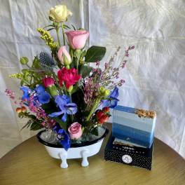 Mixed bouquet in a white vase with pink, blue, and yellow flowers